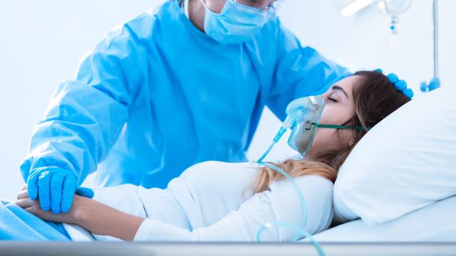 Medical professional at the bedside of an adult on oxygen
